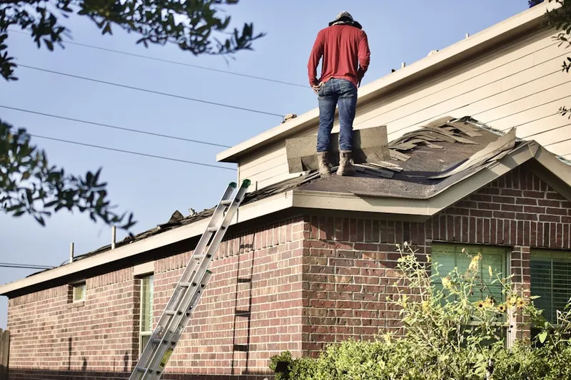 Professional roofer working on a residential roof in University Park